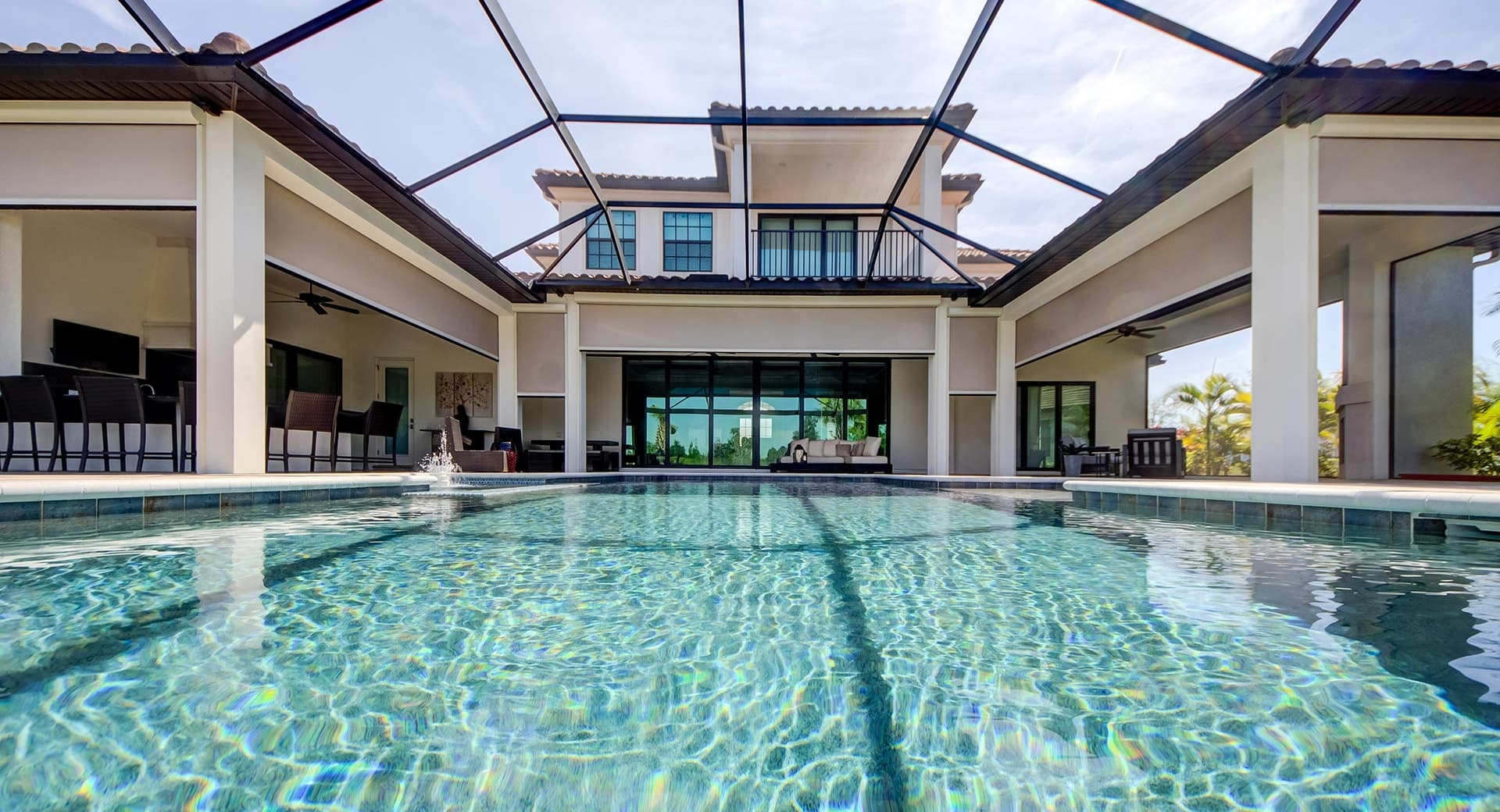 A screened Florida pool lanai with motorized roll-down sun screens